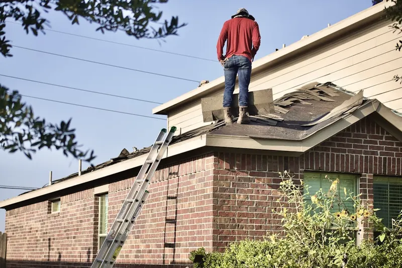 Professional roofer working on a residential roof in Dighton